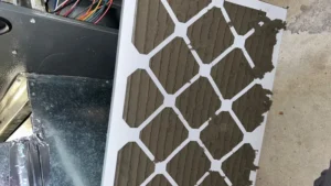 HVAC furnace air filter completely clogged with dust before replacement