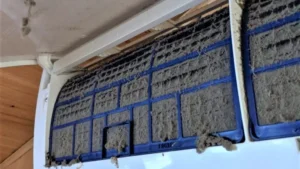 Mini-split heat pump indoor unit with dust-clogged filters before cleaning